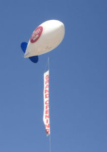 17 feet long helium advertising blimp shown in air with advertising banner